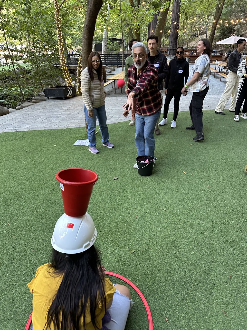 Teammates playing a ball-and-bucket challenge on the lawn at Saratoga Springs